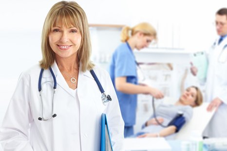 A symbolic image of a female doctor in the foreground, while in the background there is a patient lying on a bed, while the nurse and the doctor are observing her.